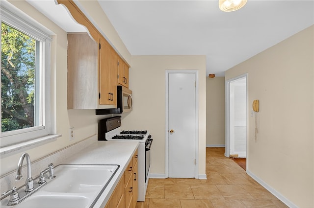 233 Ingram Ave, Ingram, PA 15205 - kitchen featuring white gas stove, stainless steel microwave, light countertops, and light tile patterned floors