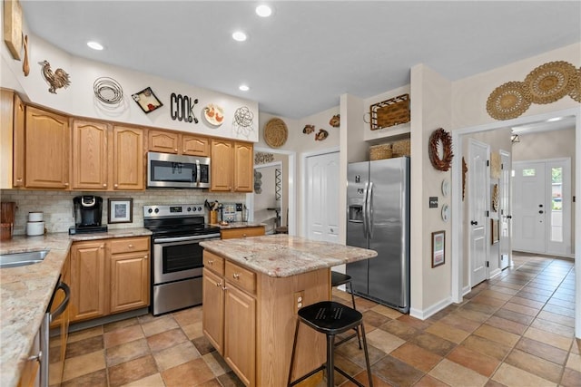 405 Crestridge Dr, Hempfield Twp, PA 15601 - kitchen with appliances with stainless steel finishes, tasteful backsplash, a breakfast bar, light stone counters, and a center island