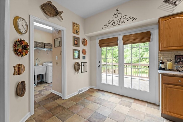 405 Crestridge Dr, Hempfield Twp, PA 15601 - doorway to outside featuring washer / dryer and light stone finish flooring