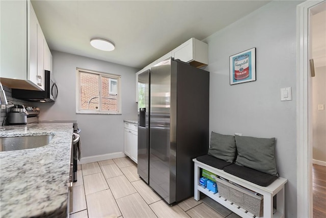 3905 Beechwood Blvd, Squirrel Hill, PA 15217 - kitchen with stainless steel fridge, white cabinetry, and light stone countertops