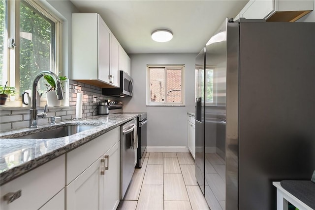 3905 Beechwood Blvd, Squirrel Hill, PA 15217 - kitchen featuring appliances with stainless steel finishes, plenty of natural light, backsplash, and white cabinets