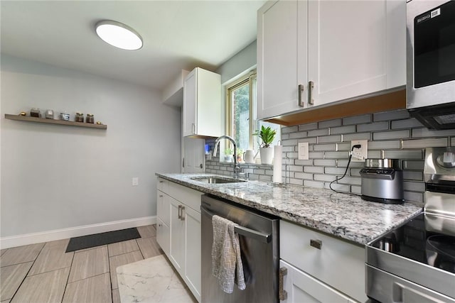 3905 Beechwood Blvd, Squirrel Hill, PA 15217 - kitchen featuring stainless steel appliances, decorative backsplash, light stone countertops, and white cabinets