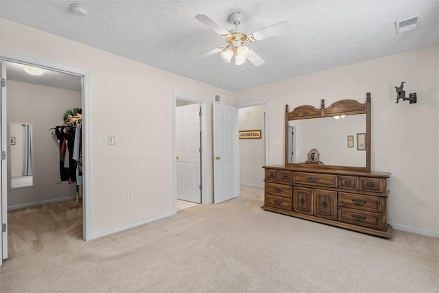 5113 Polo Fields Dr, Hampton, PA 15044 - bedroom featuring light carpet, a walk in closet, a textured ceiling, and a ceiling fan
