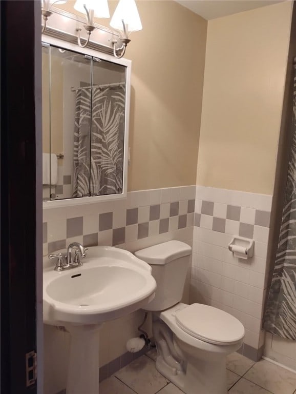 2001 7th Ave, Beaver Falls, PA 15010 - full bathroom with tile walls, a wainscoted wall, tile patterned flooring, and a shower with shower curtain