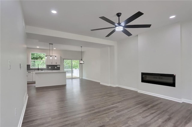 130 Center Ave, Burgettstown Boro, PA 15021 - unfurnished living room with dark wood-type flooring, a ceiling fan, a glass covered fireplace, and recessed lighting