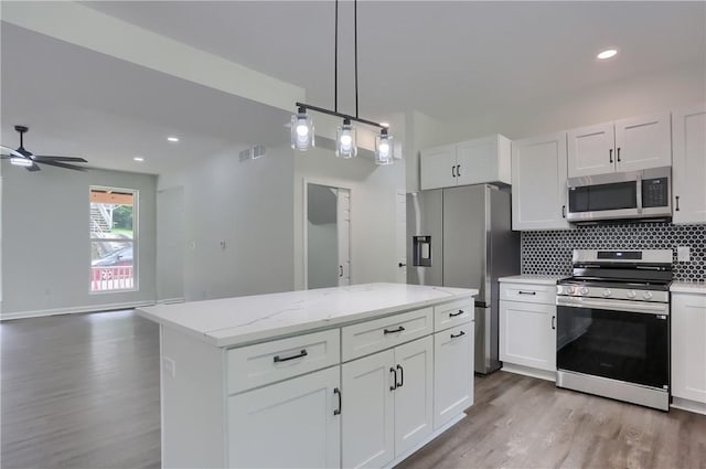 130 Center Ave, Burgettstown Boro, PA 15021 - kitchen featuring stainless steel appliances, wood finished floors, white cabinetry, decorative backsplash, and a ceiling fan