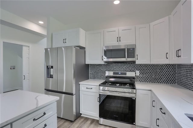130 Center Ave, Burgettstown Boro, PA 15021 - kitchen with appliances with stainless steel finishes, decorative backsplash, light stone counters, light wood-type flooring, and white cabinets