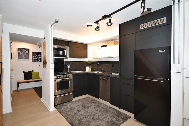 325 S Highland Ave Unit 105, Shadyside, PA 15206 - kitchen with black appliances, dark countertops, light wood finished floors, and tasteful backsplash