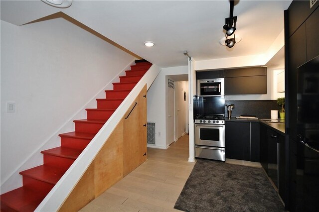 325 S Highland Ave Unit 105, Shadyside, PA 15206 - kitchen featuring modern cabinets, dark cabinets, gas stove, light wood-type flooring, and tasteful backsplash