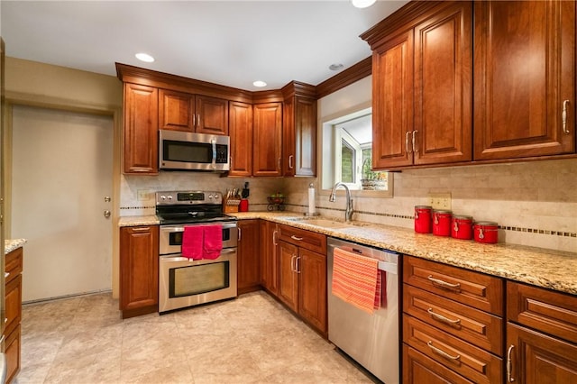 1026 Cambridge St, Harrison Twp, PA 15065 - kitchen with appliances with stainless steel finishes, backsplash, light stone countertops, brown cabinets, and recessed lighting