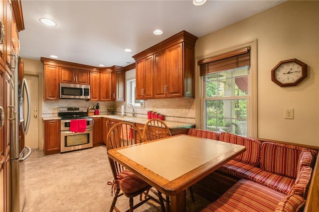 1026 Cambridge St, Harrison Twp, PA 15065 - kitchen with stainless steel appliances, decorative backsplash, recessed lighting, plenty of natural light, and brown cabinets