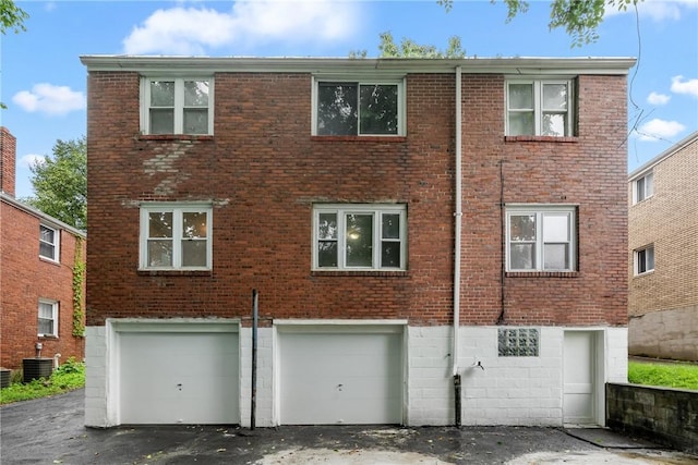 1113-1115 Woodbine, Stanton Heights, PA 15201 - back of property featuring an attached garage, brick siding, and driveway
