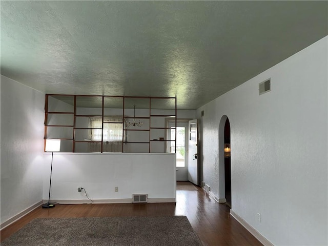 157 Elizabeth St, South Union Twp, PA 15445 - empty room with arched walkways, a textured ceiling, and dark wood finished floors