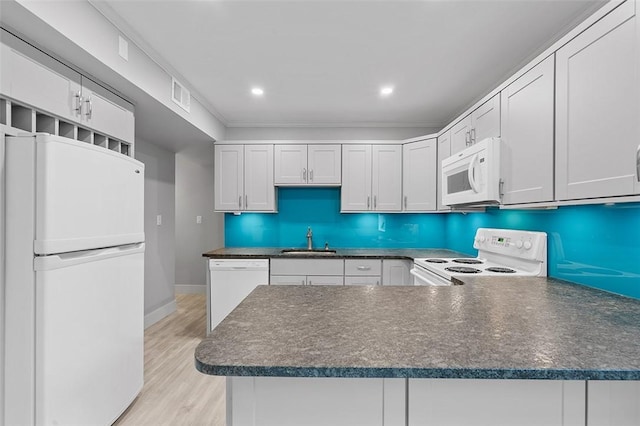 105 Camelot Dr, Mccandless, PA 15237 - kitchen featuring white appliances, dark countertops, a peninsula, light wood-style flooring, and white cabinetry