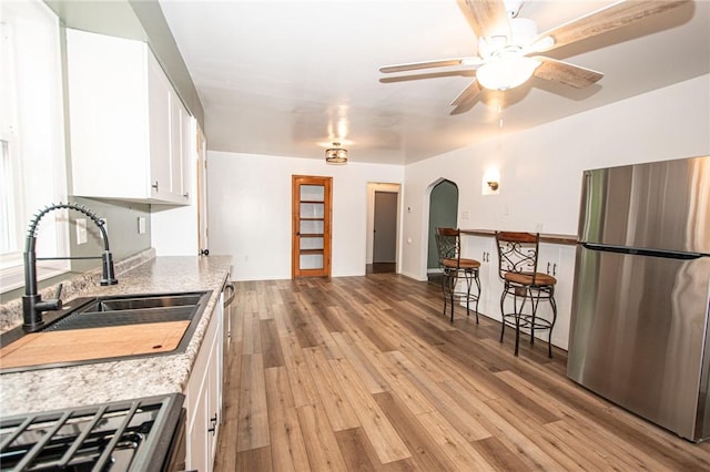 539 Park Ave, Monongahela, PA 15063 - kitchen featuring freestanding refrigerator, arched walkways, white cabinets, light wood-type flooring, and ceiling fan