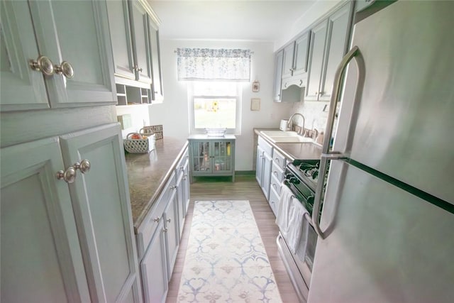 502 Lebanon Manor Dr, West Mifflin, PA 15122 - kitchen featuring freestanding refrigerator, stainless steel gas stove, and light wood-style floors