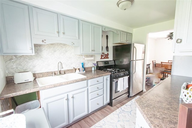 502 Lebanon Manor Dr, West Mifflin, PA 15122 - kitchen featuring gas stove, tasteful backsplash, light wood finished floors, and freestanding refrigerator