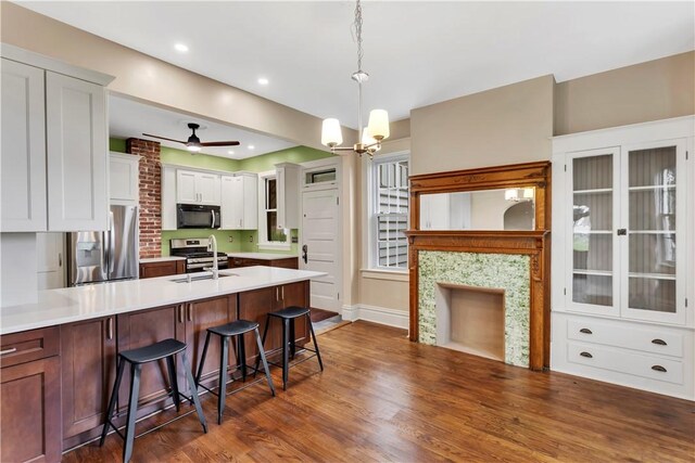 122 Haldane St, Crafton, PA 15205 - kitchen featuring appliances with stainless steel finishes, a peninsula, dark wood finished floors, a breakfast bar, and light countertops