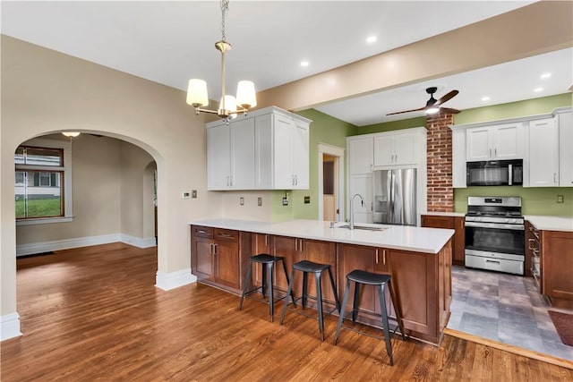 122 Haldane St, Crafton, PA 15205 - kitchen featuring appliances with stainless steel finishes, arched walkways, a peninsula, light countertops, and dark wood-style floors