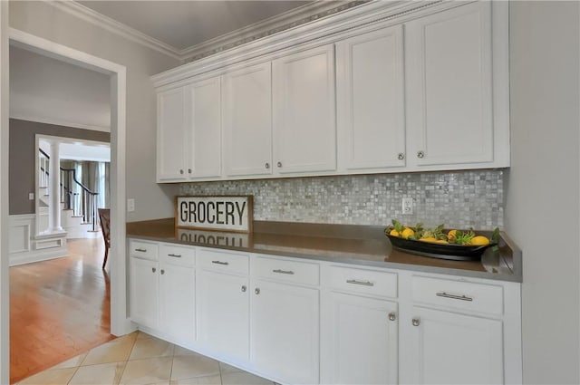 4127 Duckhorn Dr, Moon/Crescent Twp, PA 15108 - kitchen featuring crown molding, white cabinetry, decorative backsplash, dark countertops, and light wood-style floors