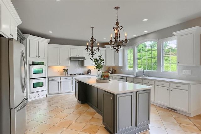 4127 Duckhorn Dr, Moon/Crescent Twp, PA 15108 - kitchen featuring stainless steel appliances, under cabinet range hood, a chandelier, a kitchen island, and light countertops