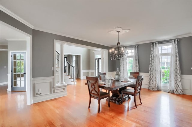 4127 Duckhorn Dr, Moon/Crescent Twp, PA 15108 - dining area with a chandelier, crown molding, light wood-style flooring, wainscoting, and a decorative wall