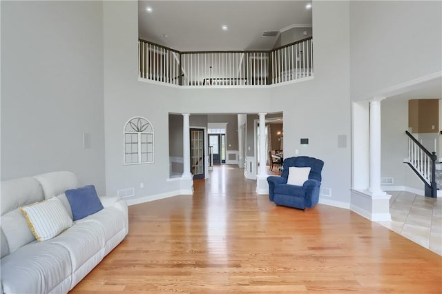4127 Duckhorn Dr, Moon/Crescent Twp, PA 15108 - living area with decorative columns, light wood-type flooring, stairs, and a towering ceiling