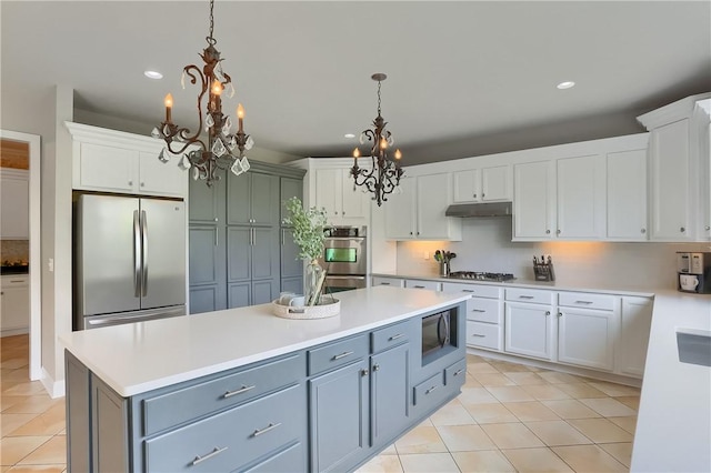 4127 Duckhorn Dr, Moon/Crescent Twp, PA 15108 - kitchen with appliances with stainless steel finishes, a chandelier, light tile patterned floors, under cabinet range hood, and recessed lighting