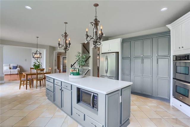 4127 Duckhorn Dr, Moon/Crescent Twp, PA 15108 - kitchen with stainless steel appliances, a chandelier, light tile patterned floors, gray cabinetry, and recessed lighting