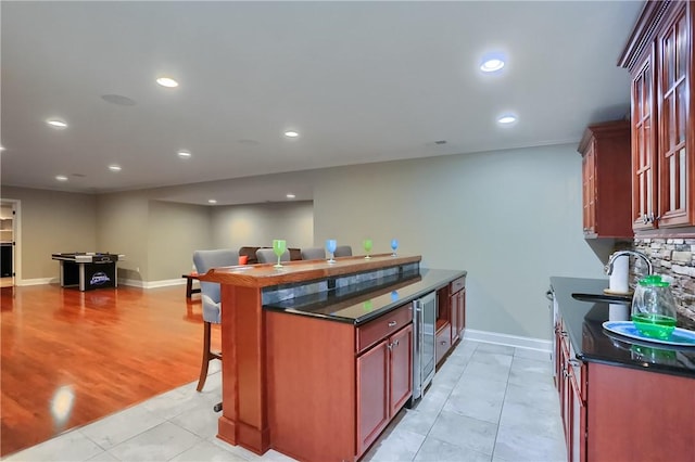4127 Duckhorn Dr, Moon/Crescent Twp, PA 15108 - kitchen featuring wine cooler, a breakfast bar area, open floor plan, reddish brown cabinets, and recessed lighting