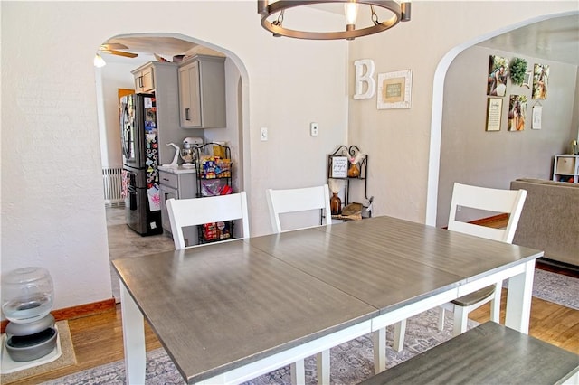 1109 N 2nd St, Jeannette, PA 15644 - dining room with arched walkways, radiator heating unit, and light wood-style flooring