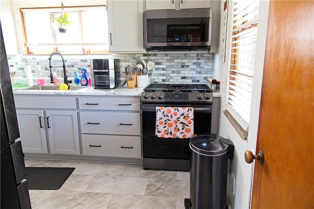 1109 N 2nd St, Jeannette, PA 15644 - kitchen with stainless steel appliances, backsplash, and light countertops
