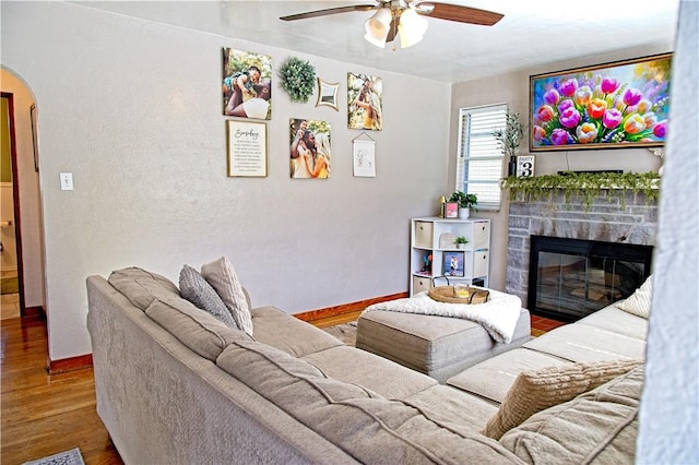 1109 N 2nd St, Jeannette, PA 15644 - living area with arched walkways, a ceiling fan, wood finished floors, and a fireplace