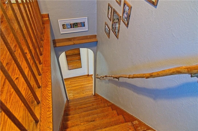 1109 N 2nd St, Jeannette, PA 15644 - staircase featuring wood finished floors, a textured wall, and arched walkways