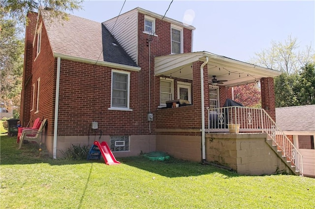 1109 N 2nd St, Jeannette, PA 15644 - back of property featuring ceiling fan, brick siding, a lawn, roof with shingles, and stairway