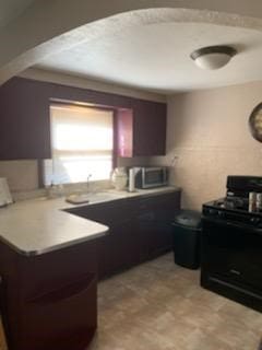 19 Charles St, Dravosburg, PA 15034 - kitchen featuring stove, a peninsula, and light countertops