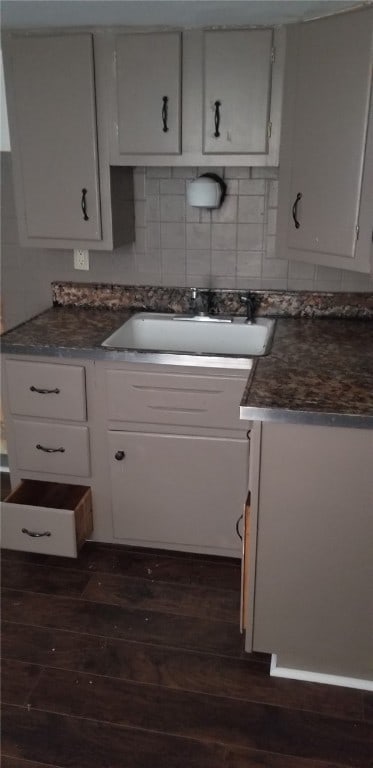 19 Charles St, Dravosburg, PA 15034 - kitchen with dark wood-type flooring, dark countertops, tasteful backsplash, and white cabinetry