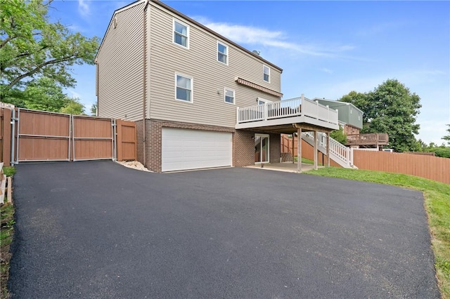 249 Clare Dr, North Strabane, PA 15317 - back of property with brick siding, a deck, a gate, stairway, and an attached garage