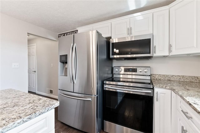 249 Clare Dr, North Strabane, PA 15317 - kitchen featuring stainless steel appliances, white cabinets, dark wood finished floors, a textured ceiling, and light stone countertops