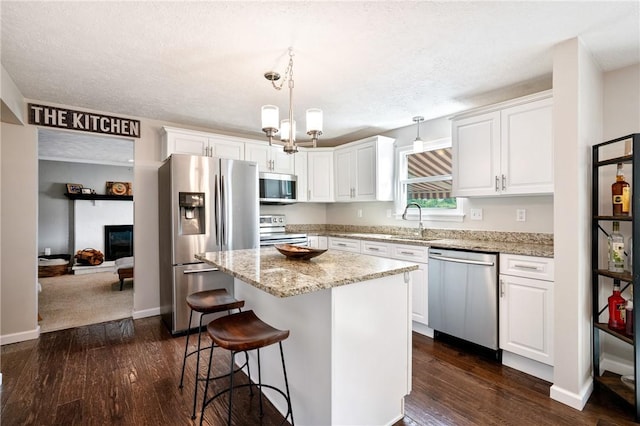249 Clare Dr, North Strabane, PA 15317 - kitchen with appliances with stainless steel finishes, dark wood-style floors, white cabinets, a center island, and a textured ceiling