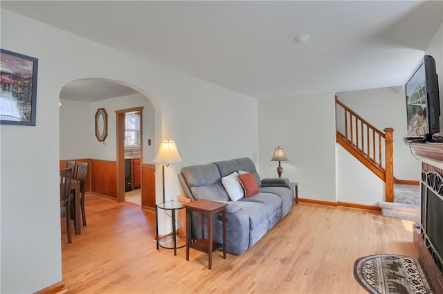 1009 Roselawn Ave, Harmony Twp, PA 15003 - living room featuring arched walkways, light wood finished floors, and stairs