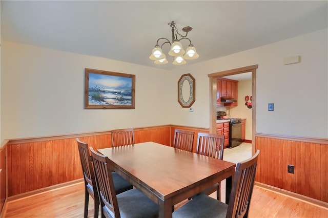 1009 Roselawn Ave, Harmony Twp, PA 15003 - dining area with a wainscoted wall, light wood-style flooring, a chandelier, and wooden walls