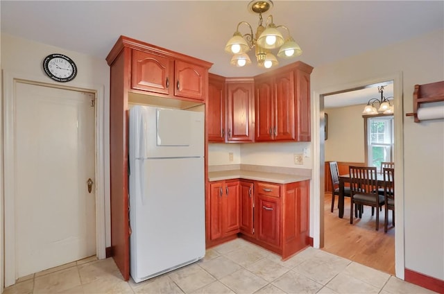 1009 Roselawn Ave, Harmony Twp, PA 15003 - kitchen featuring freestanding refrigerator, a chandelier, light countertops, and light tile patterned floors