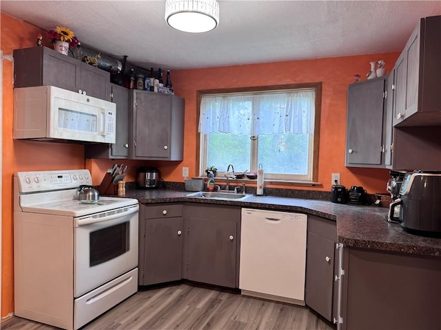 1077 Bechtol Ave, Sharon, PA 16146 - kitchen with white appliances, dark countertops, light wood finished floors, and gray cabinetry