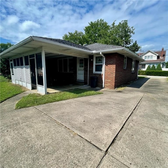 408 Ekin St, Elizabeth Twp/Boro, PA 15037 - view of front of property featuring brick siding, driveway, a sunroom, and a shingled roof
