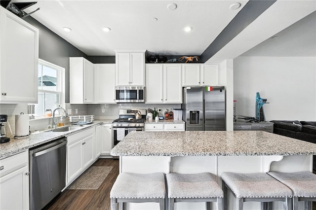 4022 Crown Dr, South Park, PA 15129 - kitchen with appliances with stainless steel finishes, a kitchen island, dark wood-type flooring, light stone counters, and recessed lighting