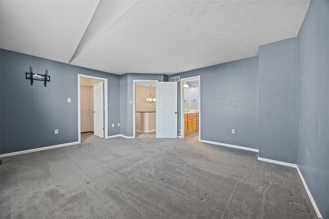 2692 Hunters Point Dr, Franklin Park, PA 15090 - unfurnished bedroom featuring a spacious closet, carpet, ensuite bathroom, and a textured ceiling