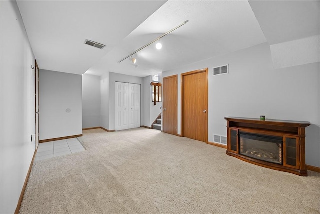 2692 Hunters Point Dr, Franklin Park, PA 15090 - unfurnished living room with rail lighting, stairway, light carpet, and a glass covered fireplace