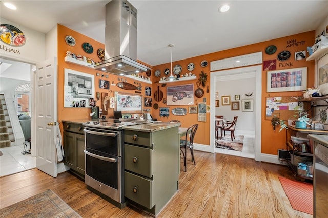 303 Schenley Rd, Squirrel Hill, PA 15217 - kitchen featuring range with two ovens, island range hood, green cabinets, light wood-type flooring, and recessed lighting