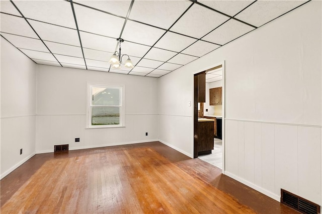1307 Wade St, Aliquippa, PA 15001 - empty room featuring wood finished floors, a paneled ceiling, and a chandelier